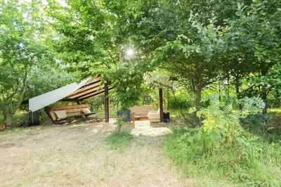 a tent sitting under a tree in a field at Little Lodge Glamping in Halesworth
