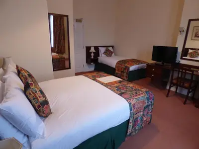 a hotel room with two beds and a television at Arundel House Hotel in Cambridge