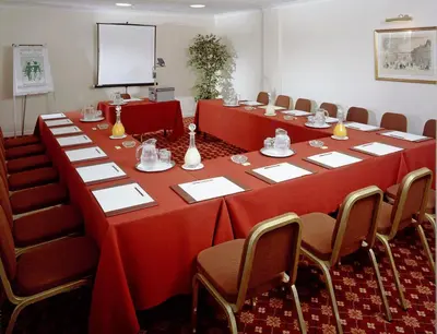 a conference room with a long table and chairs at Arundel House Hotel in Cambridge