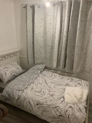 an unmade bed in a bedroom with a curtain at At Apex House single room in Horndon on the Hill