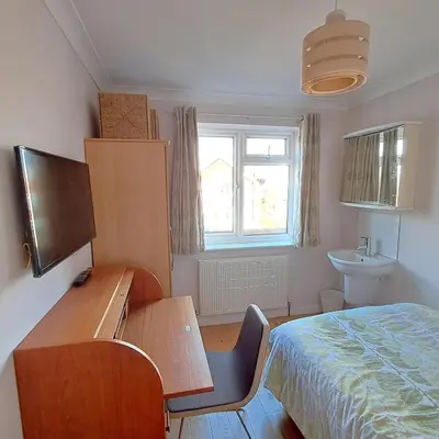 a bedroom with a desk and a bed and a sink at Scandi inspired holiday home Brentwood in Brentwood