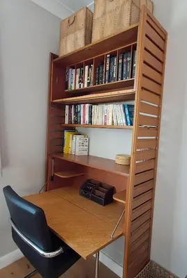 a book shelf with a desk and a chair at Scandi inspired holiday home Brentwood in Brentwood