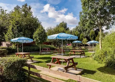 a group of picnic tables with umbrellas in a park at Roydon Marina Village in Roydon