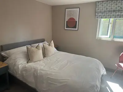 a bed with white sheets and pillows in a bedroom at Lavender Lodge - Pool and Hot Tub with sunset views over open fields in Wymondham