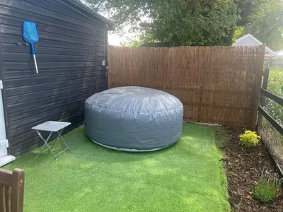 a garden with a bean bag chair and a fence at Lavender Lodge - Pool and Hot Tub with sunset views over open fields in Wymondham