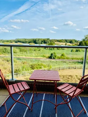 two chairs and a table on a balcony with a view at Riverside Haven in Woodbridge in Woodbridge