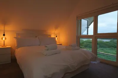 a bedroom with a white bed with towels on it at Riverside Haven in Woodbridge in Woodbridge