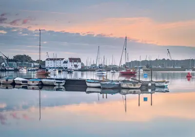 a group of boats are docked in a harbor at Riverside Haven in Woodbridge in Woodbridge