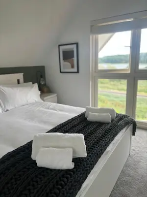 a bedroom with a bed with two towels on it at Riverside Haven in Woodbridge in Woodbridge