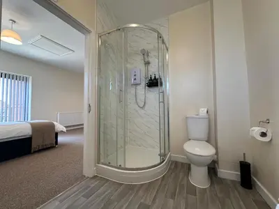 a bathroom with a shower and a toilet in a room at New Luxury flats in Ipswich