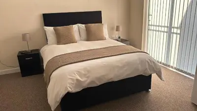 a bedroom with a large bed with two night stands at New Luxury flats in Ipswich