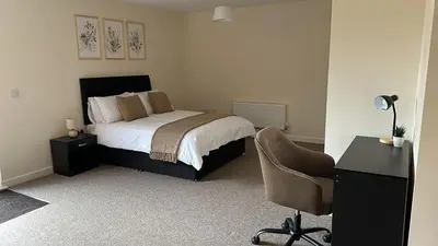 a bedroom with a bed and a desk and a chair at New Luxury flats in Ipswich