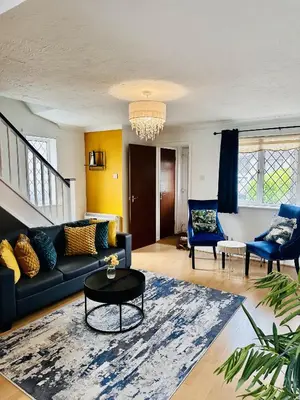 a living room with a black couch and blue chairs at Kinlett close in Mile End
