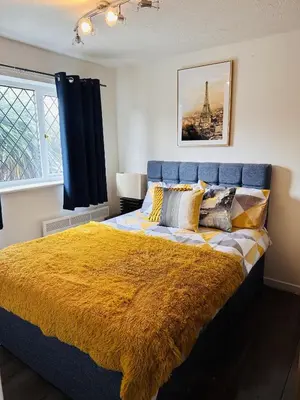 a bedroom with a large bed with a yellow blanket at Kinlett close in Mile End