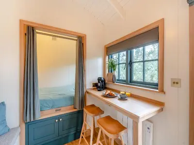 a tiny house with a desk and a window at Shepherd's Retreat in Ongar