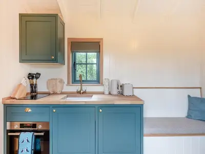 a kitchen with blue cabinets and a sink at Shepherd's Retreat in Ongar