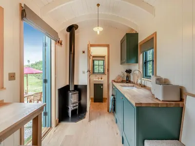 a kitchen with blue cabinets and a wood stove at Shepherd's Retreat in Ongar