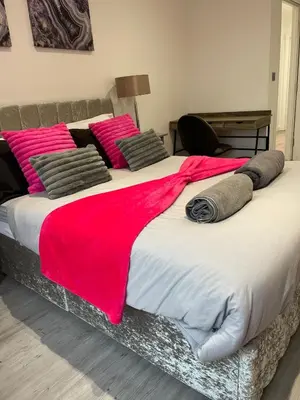 a large bed with a red blanket on it at 1 Bedroom Apartment By Brookland Stays Serviced Accommodation Short Lets Essex With Free WIFI in Brentwood