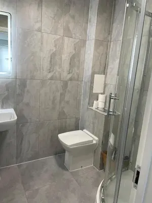 a bathroom with a toilet and a glass shower at 1 Bedroom Apartment By Brookland Stays Serviced Accommodation Short Lets Essex With Free WIFI in Brentwood