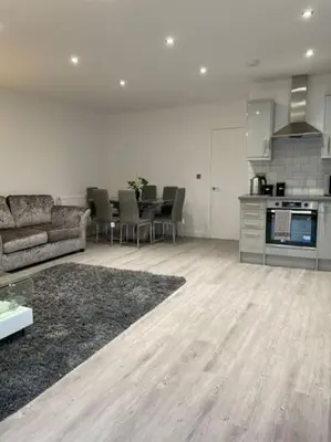 a large living room with a couch and a kitchen at 1 Bedroom Apartment By Brookland Stays Serviced Accommodation Short Lets Essex With Free WIFI in Brentwood