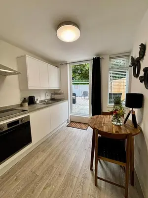 a kitchen with a wooden table and a dining room at Stylish and Chic Seaside Apartment in Southend-on-Sea