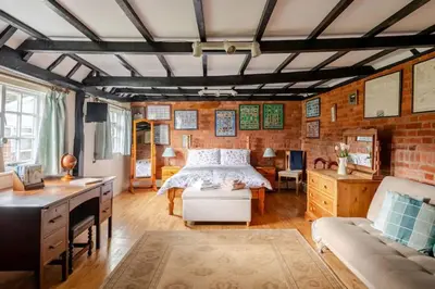 a bedroom with a bed and a brick wall at Cozy One-Bedroom Cottage in Great Tey in Great Tey