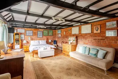 a bedroom with a bed and a brick wall at Cozy One-Bedroom Cottage in Great Tey in Great Tey