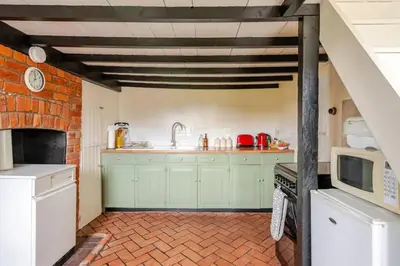a kitchen with green cabinets and a microwave at Cozy One-Bedroom Cottage in Great Tey in Great Tey