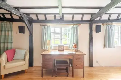 a desk and a chair in a room with a window at Cozy One-Bedroom Cottage in Great Tey in Great Tey