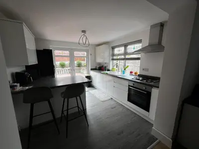 a kitchen with white cabinets and a black counter top at Cozyleigh in Southend-on-Sea