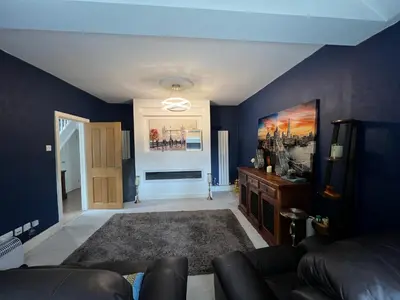a living room with blue walls and a couch at Cozyleigh in Southend-on-Sea