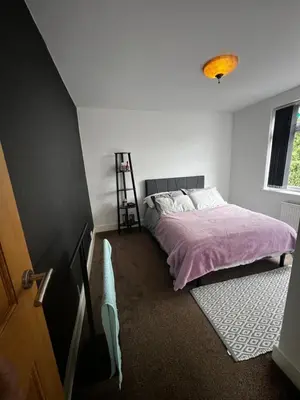 a bedroom with a bed with a pink blanket at Cozyleigh in Southend-on-Sea