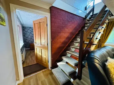 a staircase with a red brick wall and a door at Contractors families free parking Ramsey Road in St Ives
