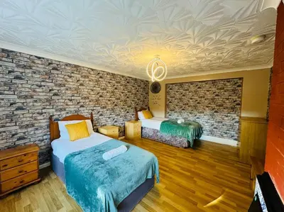 a bedroom with two beds and a brick wall at Contractors families free parking Ramsey Road in St Ives