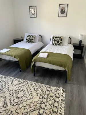 a bedroom with two beds and a rug at Royal Oak Apartments 7 - Free Secure Parking - 2 Bedroom - Perfect for Contractors in Brentwood