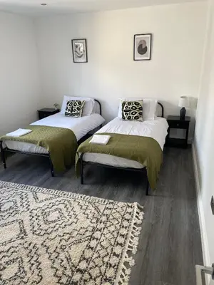 a bedroom with two beds and a rug at Royal Oak Apartments 7 - Free Secure Parking - 2 Bedroom - Perfect for Contractors in Brentwood