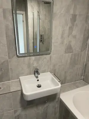 a bathroom with a white sink and a mirror at Royal Oak Apartments 7 - Free Secure Parking - 2 Bedroom - Perfect for Contractors in Brentwood
