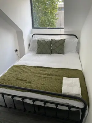 a bed in a small room with a window at Royal Oak Apartments 7 - Free Secure Parking - 2 Bedroom - Perfect for Contractors in Brentwood