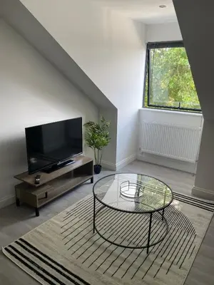 a living room with a tv and a glass table at Royal Oak Apartments 7 - Free Secure Parking - 2 Bedroom - Perfect for Contractors in Brentwood