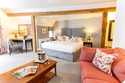 a hotel room with a bed and a couch at Swan Hotel & Spa in Lavenham