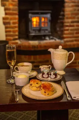 a table with a plate of food and a glass of wine at Swan Hotel & Spa in Lavenham