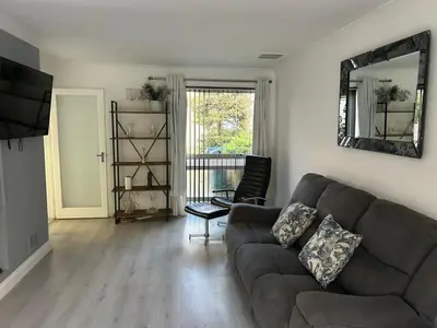 a living room with a couch and a mirror at Truehome Close to Stansted Airport in Harlow