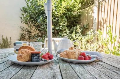 a table with two plates of croissants and strawberries at Captain's Quarters, a ground floor apartment in Aldeburgh in Aldeburgh