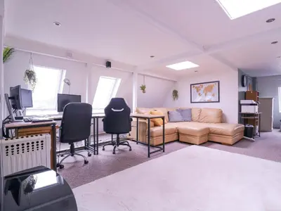 a living room with a couch and a desk with a computer at Home by the Sea in Clacton-on-Sea