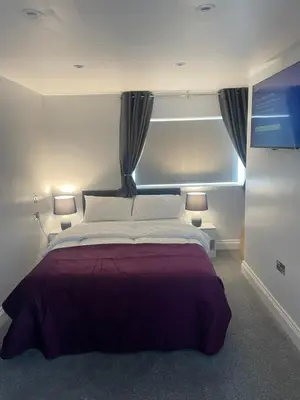 a bedroom with a large bed with a window at Cozy Studio Flat - Romford, London in Havering atte Bower