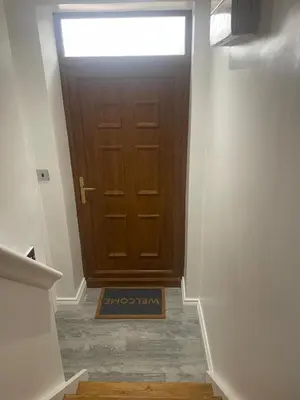 a hallway with a door with a sign in front at Cozy Studio Flat - Romford, London in Havering atte Bower