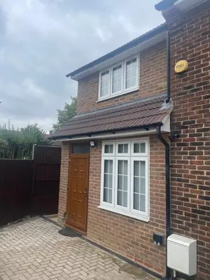 a brick house with a brown door and white windows at Cozy Studio Flat - Romford, London in Havering atte Bower