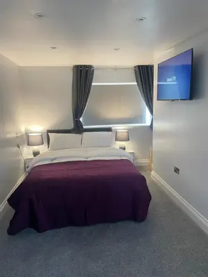 a bedroom with a large bed with a large window at Cozy Studio Flat - Romford, London in Havering atte Bower
