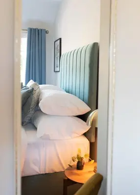 a bedroom with a pile of pillows on a bed at 3 Bedroom House with Courtyard Garden and Parking in Chesterton