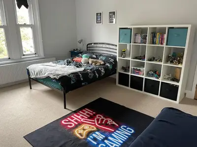 a bedroom with a bed and a book shelf at Beautiful family home with hot tub in Wivenhoe